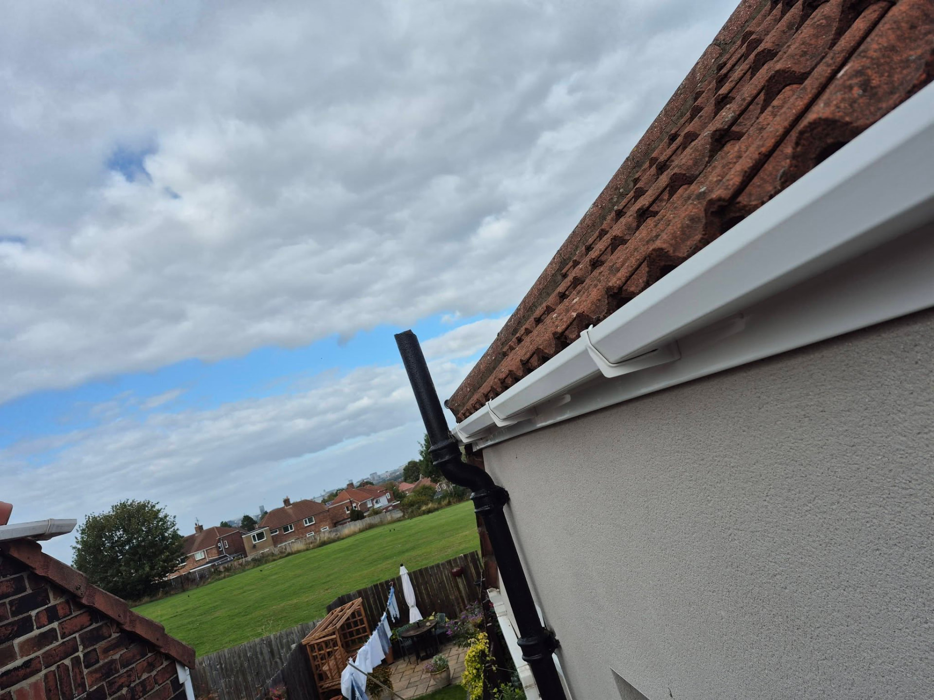 Completed white guttering and black downpipe on a residential property