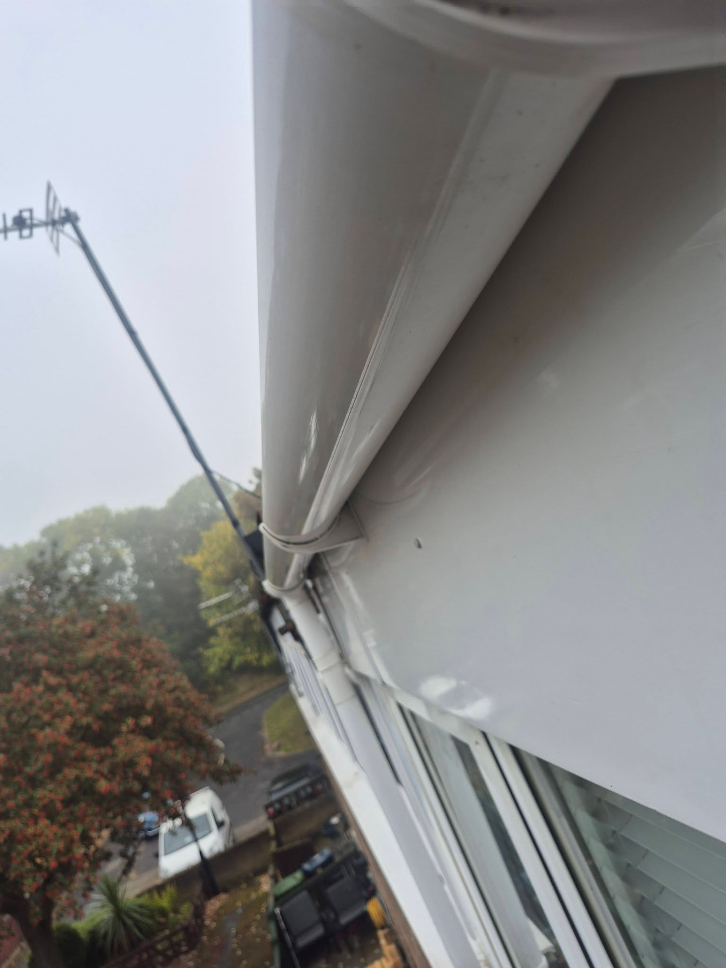 Close-up inspection of clean white guttering above a window