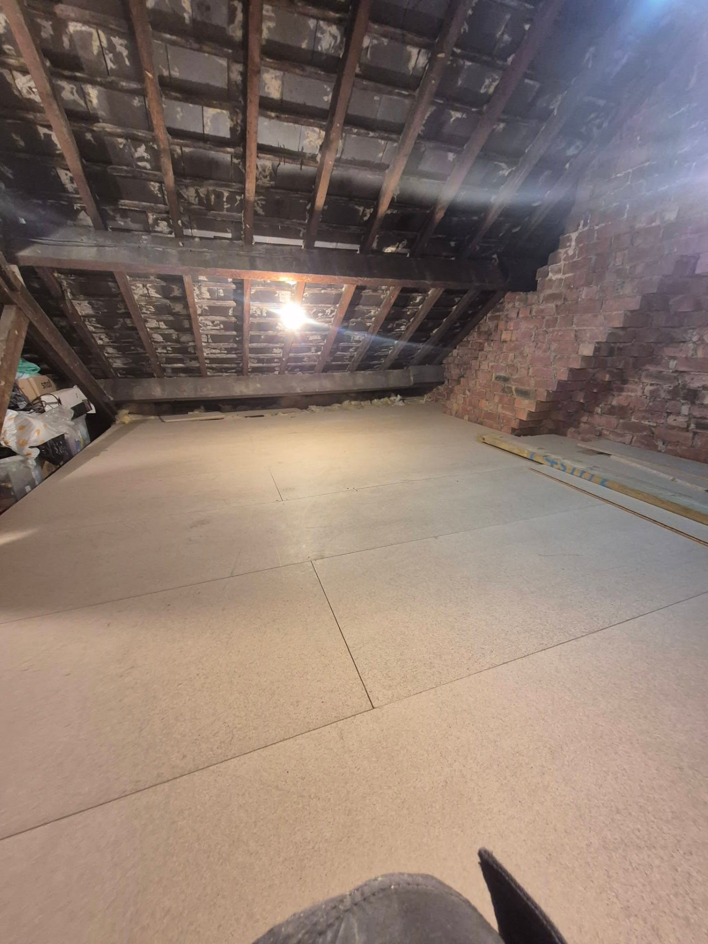 Completed loft boarding viewed beneath timber rafters